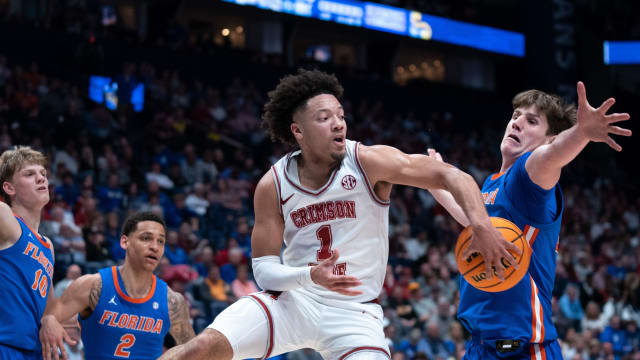 Alabama Crimson Tide guard Mark Sears (1) makes a no-look pass beneath Florida Gators forward Alex Condon (21) during their SEC Men's Basketball Tournament quarterfinal game at Bridgestone Arena in Nashville, Tenn., Friday, March 15, 2024.at Bridgestone Arena in Nashville, Tenn., Friday, March 15, 2024.